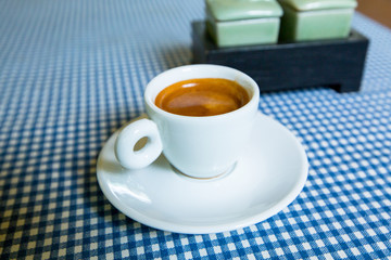 A cup of espresso on a table.