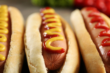Tasty hot-dogs with vegetables on wooden background, close up