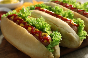 Tasty hot-dogs with chips and pickled cucumbers on wooden background, close up