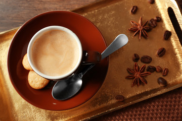 Cup of coffee on tray, on wooden table background