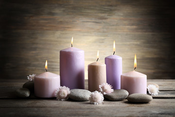 Fototapeta na wymiar Spa set with candles, pebbles and flowers on wooden background