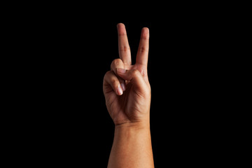 human hand forming a victory sign over a black color background