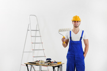 Worker renewing apartment on wall background