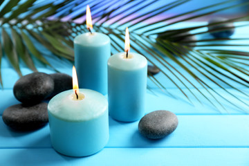 Obraz na płótnie Canvas Spa composition of blue candles, stones on blue background