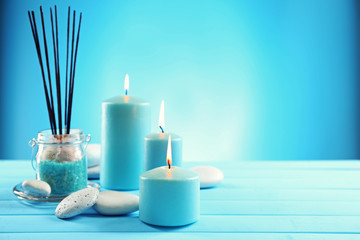 Obraz na płótnie Canvas Spa composition of blue candles, stones and sea salt on blue background