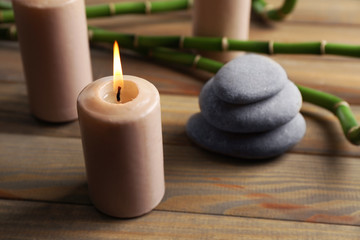 Obraz na płótnie Canvas Spa composition of candles, stones and bamboo on wooden background