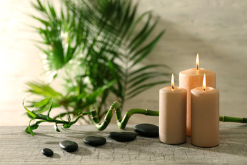 Fototapeta na wymiar Spa composition of candles, stones and bamboo on light background