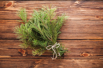 Christmas bouquet of fir tree branch on wooden background