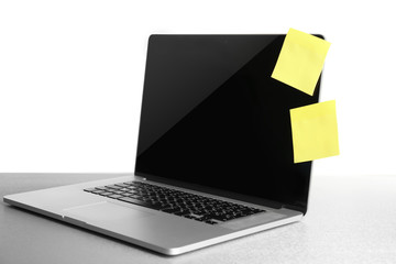 Empty yellow adhesive papers on laptop, on light background