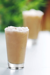 Cups of ice coffee on light blurred background