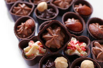 Delicious chocolate candies on white background, close up