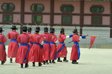 Fototapeta na wymiar Row of armed guards in ancient traditional soldier uniforms in the old royal residence, Seoul, South Korea..