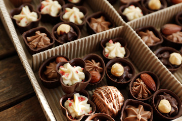 Different chocolate candies in paper box, close up