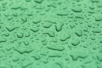 Drop water rain on the green car in close up background and text