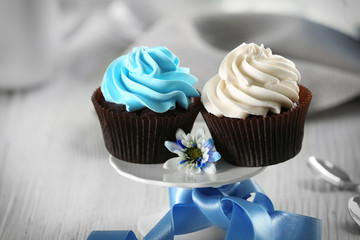 Chocolate cupcakes with colourful cream on decorated table , close up