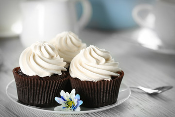 Tasty cupcakes on white saucer, close up
