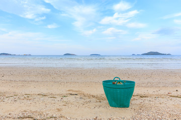 Fototapeta na wymiar Green Waste basket on the beach