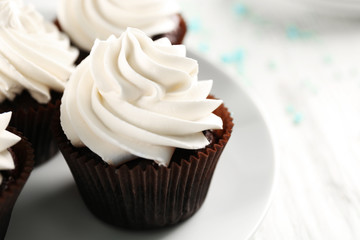 White cupcakes on wooden table