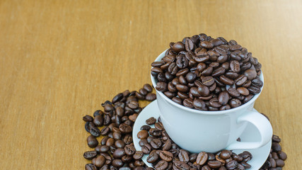 Cup of coffee and coffee bean on wooden, selective focus