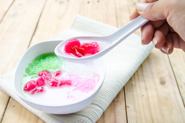 Tub Tim Krob ,Stuffed Water Chestnut in Syrup and Coconut Milk on wood table thailand dessert