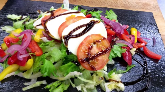 Fresh tomato-mozzarella salad, with balsamico sauce, at a restaurant kitchen
