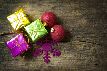 Red ball and stacks of Christmas presents on the wooden backgrou