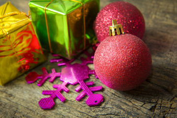 Red ball over the stacks of Christmas presents on the wooden bac