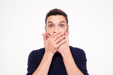 Shocked stunned young man covered mouth by hands