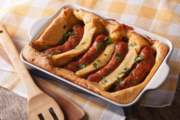 English food: toad in the hole into a baking dish close up. Horizontal
