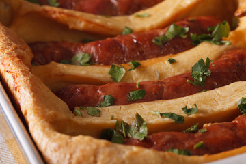 sausage baked in pastry in a dish macro. horizontal
