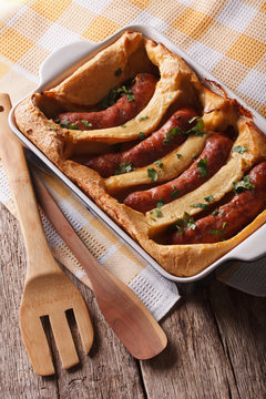 English food: toad in the hole into a baking dish close up. Vertical
