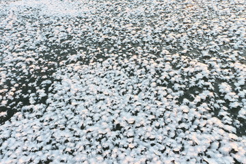 Snow cover of a freakish form on ice of the frozen river,  natural background

