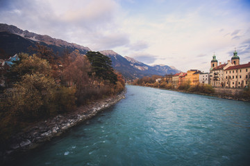 Fototapeta premium Beautiful super wide-angle aerial view of Innsbruck, Austria with skyline, Alps mountains and scenery beyond the city, and Inn river 