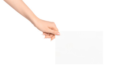 Branding and advertising theme: beautiful female hand holding a blank white paper card isolated on white background