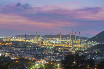 Oil refinery among the city at twilight.
