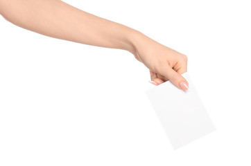 Branding and advertising theme: beautiful female hand holding a blank white paper card isolated on white background