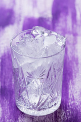 Glass of ice cubes on the wooden background