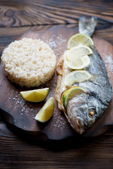Baked dorado with brown rice, close-up, selective focus