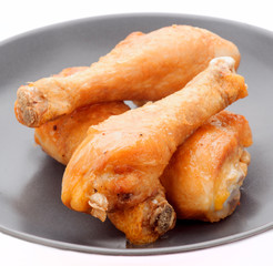 fried chicken thighs in dark porcelain dish