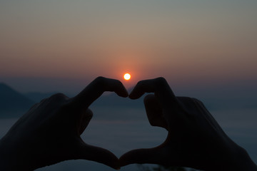 Silhouette heart with sunrise.