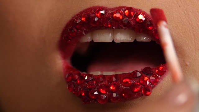 Luxury woman with rhinestones on her lips. Slow motion. close up