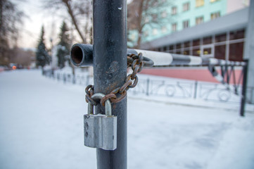 Металлический замок висит на ржавой железной цепи.