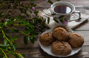tea and cookies and fresh flowers  on a wooden table  