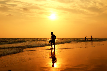 Fototapeta premium Silhouette of boy playing on the beach at sunset