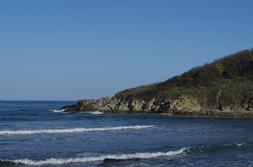 Fototapeta na wymiar Acute rocky headland juts out into the sea