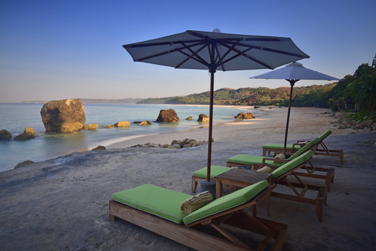 Sun loungers and parasols on beach in morning, West Sumba, Indonesia