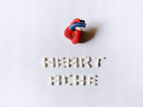 Conceptual heart and heartache made from play dough and pills