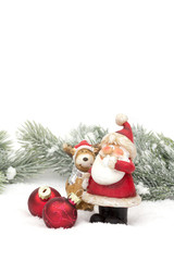 Fototapeta na wymiar Weihnachtsmann mit Elch im Schnee mit Tannenzweigen und Kugeln
