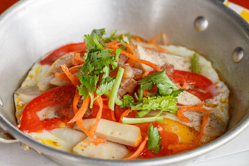Close up pan-fried egg with pork and toppings on breakfast tradi
