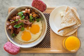 sunny side up fried egg breakfast served with sausages bacon and toast